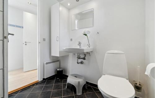 3 Bedroom Cozy Home In Aakirkeby في Vester Sømarken: حمام ابيض مع مرحاض ومغسلة