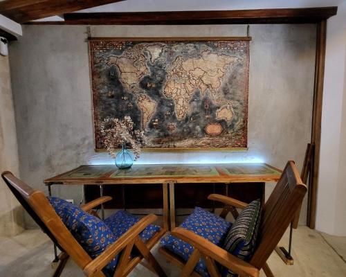 einen Tisch und Stühle mit einer Karte an der Wand in der Unterkunft Casa de Koras in Cullera