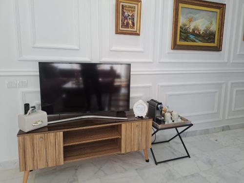 a flat screen tv sitting on top of a wooden table at Studio Casablanca aéroport nouaceur in Nouaceur