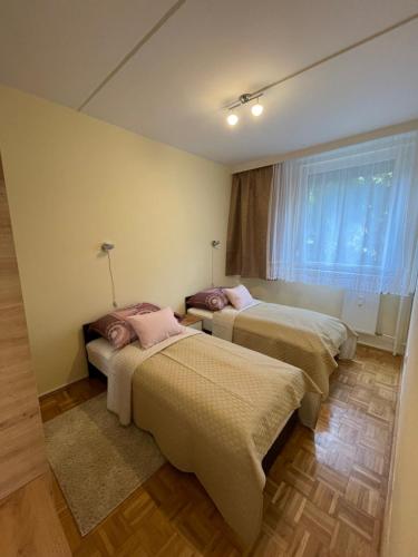 two beds in a room with a window at Gvadányi Rezidencia in Budapest