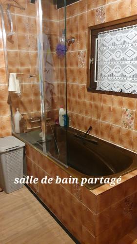 La salle de bains est pourvue d'une baignoire noire et d'un miroir. dans l'établissement Chambre zen, à Motteux