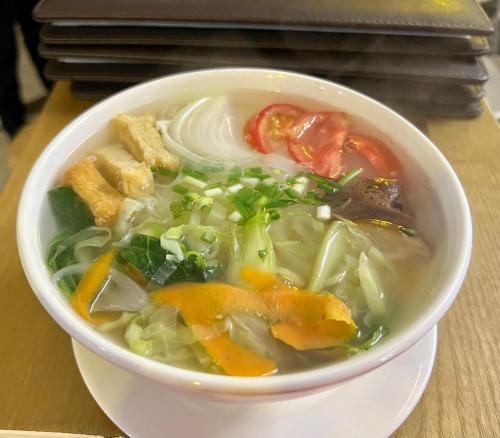 a bowl of soup sitting on a table at Fancy Hostel and Bar in Ha Long