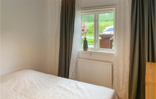 a bedroom with a bed and a window with a vase of flowers at Amazing Home In Ydre With Wifi in Idebo