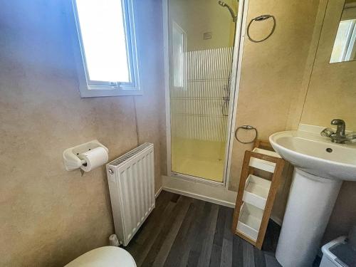 a bathroom with a toilet and a sink and a shower at Brilliant 10 Berth Caravan At Valley Farm Holiday Park, Essex Ref 46443v in Great Clacton