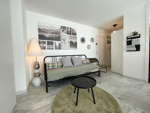 - une chambre avec un lit, un tabouret et une table dans l'établissement Le guynemer, à Beausoleil