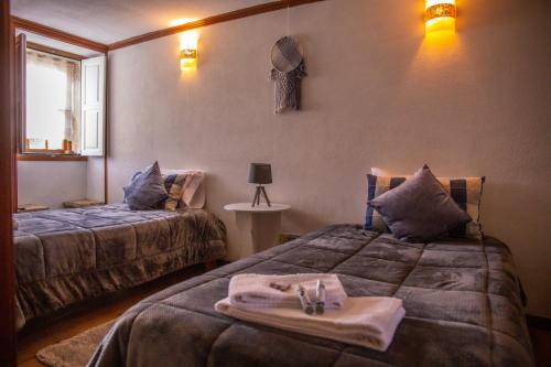 - une chambre d'hôtel avec 2 lits et des serviettes dans l'établissement Casa da Cerca, à Sortelha