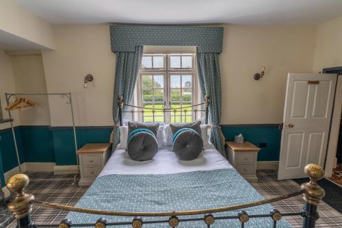 a bedroom with a bed with pillows and a window at Blackgreaves Farmhouse in Lea Marston