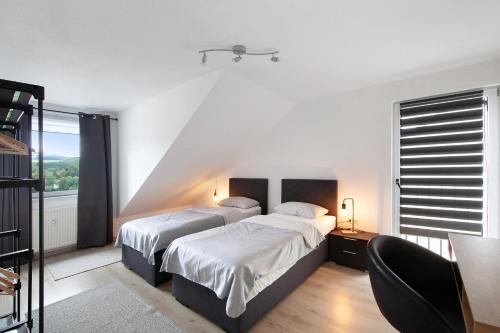 a bedroom with two beds and a window at Ferienwohnung zur Nordhelle in Herscheid
