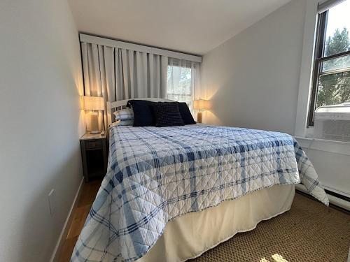 a bedroom with a bed with a blue and white blanket at 6 Mechanic in Provincetown