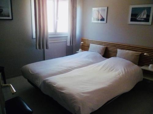 sypialnia z 2 łóżkami z białą pościelą i oknem w obiekcie Hauts de Portissol 50 m2 terrasse 12 m2 Vue mer w mieście Sanary-sur-Mer