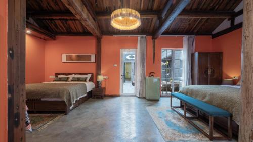 a bedroom with two beds and orange walls at Hotel Cote Cour Deductive Beijing - Quadrangle close to Tiananmen Square & Forbidden City & Nanluoguxiang, Walk to Wangfujing, English speaking, Free WiFi, Free Laundry, Free Wonton & Noodles with Tour ticket service, Free selfies with ancient costume in Beijing