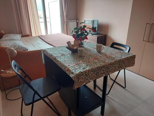 a room with a table and a bedroom with a bed at A spasso in Ventimiglia