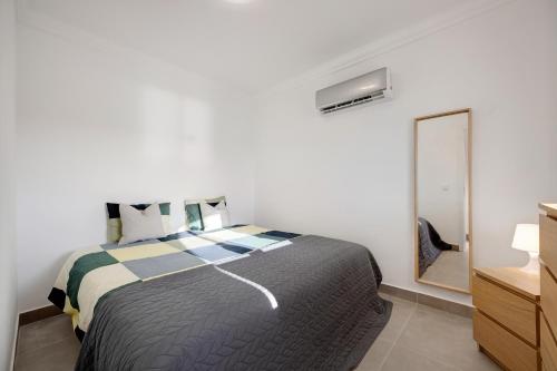 a bedroom with a large bed and a mirror at Yasmim House in Sagres