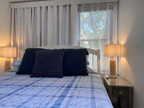 a bedroom with a bed with two lamps and a window at 6 Mechanic in Provincetown
