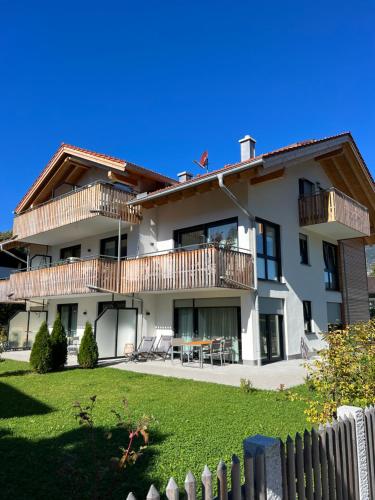 una casa bianca con una recinzione davanti di Hubertus Terrace&Garden Apartment a Garmisch-Partenkirchen