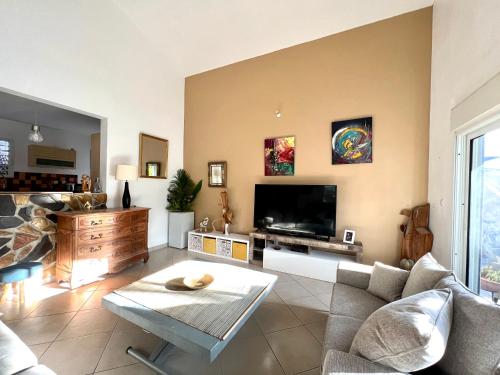 uma sala de estar com um sofá e uma televisão em Villa Ti MoOn, Entre deux, Piscine em Entre-Deux