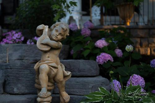 a statue of a little boy standing in a garden at Maxwell Mansion Hotel in Lake Geneva