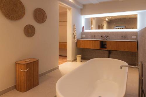 a bathroom with a tub and a large mirror at Newly renovated luxurious 200 SQM loft in city centre in Amsterdam