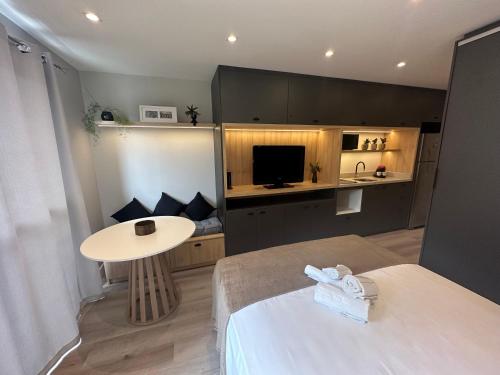 a room with a bed and a table and a kitchen at Loft no Bairro Auxiliadora in Porto Alegre