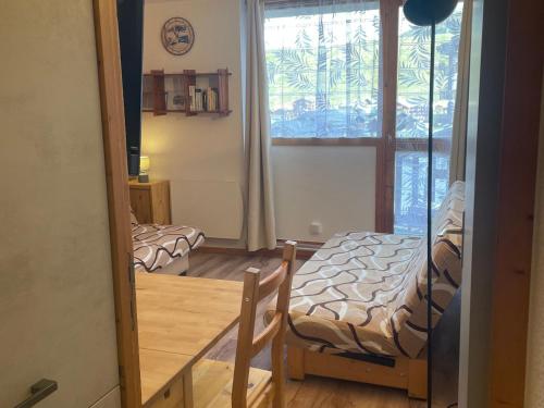 une chambre avec deux lits et une fenêtre dans l'établissement Studio rénové, pieds des pistes, balcon - FR-1-181-2717, à La Plagne Tarentaise