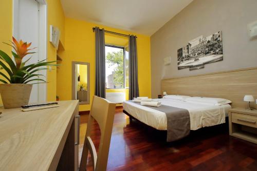 ein Hotelzimmer mit einem Bett und einem Schreibtisch in der Unterkunft LHG Comfy Rooms in Rom