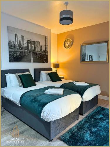 a bedroom with two beds and a painting on the wall at Minehead Suite in Minehead