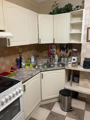 a kitchen with white cabinets and a sink at Janis poils home 1 in Ventspils