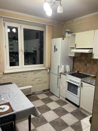 a kitchen with white appliances and a checkered floor at Janis poils home 1 in Ventspils