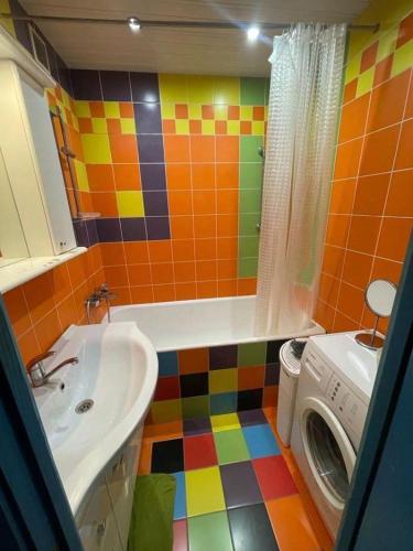 a colorful bathroom with a sink and a washing machine at Janis poils home 1 in Ventspils