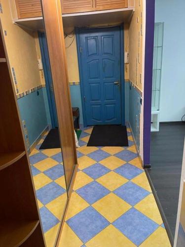 a hallway with a blue door and a checkered floor at Janis poils home 1 in Ventspils
