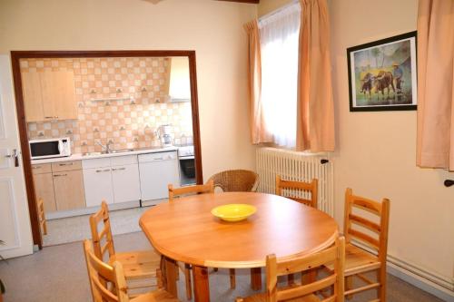 - une table à manger avec des chaises et un bol jaune dans l'établissement Résidence Torremagne 6, à Font-Romeu-Odeillo-Via