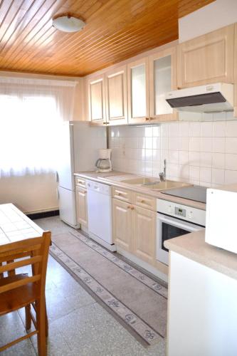 une cuisine avec des appareils blancs et un plafond en bois dans l'établissement Grand appartement à Font Romeu vue panoramique montagne Torremagne 3, à Font-Romeu-Odeillo-Via