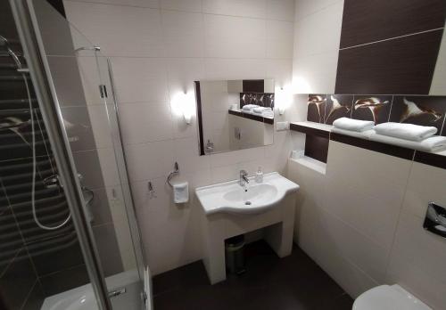 a bathroom with a sink and a shower at Restauracja Kargul noclegi in Łęczyca