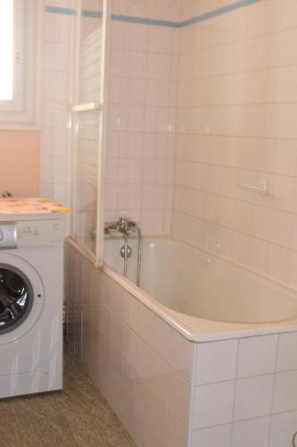 une salle de bain avec baignoire et machine à laver dans l'établissement Résidence Torremagne 4, à Font-Romeu-Odeillo-Via