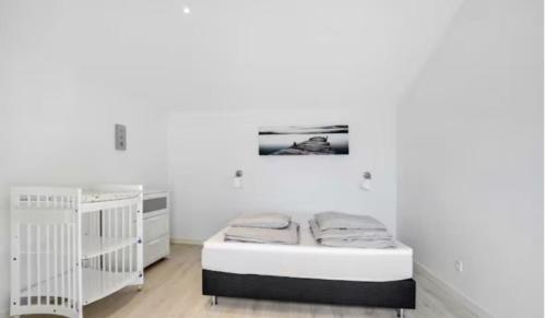 ein weißes Zimmer mit 2 Betten und Kinderbetten in der Unterkunft Skønt luksus Spa hus in Børkop