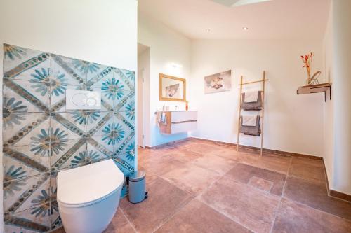 a bathroom with a toilet and a tile floor at Naturliebe Samerberg in Samerberg