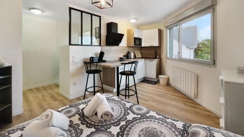 Habitación con cama y cocina con mesa en Studio cosy élégant, en Villeurbanne