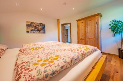 een slaapkamer met een bed met een dekbed erop bij Naturliebe Samerberg in Samerberg