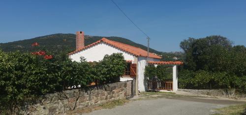 a white house with a stone wall next to a building at Antoneiko house 