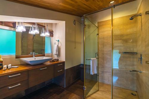 a bathroom with a sink and a shower at StayVista at Ludlow House Luxury 4BHK Valley View villa in Kasauli with Sauna room in Kasauli