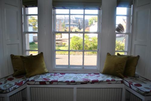 a window seat in a room with two windows at Merchants House- stunning seaview period home in Anstruther