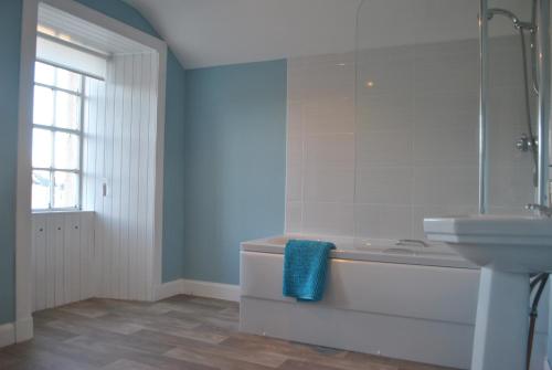 a bathroom with a bath tub and a sink at Merchants House- stunning seaview period home in Anstruther