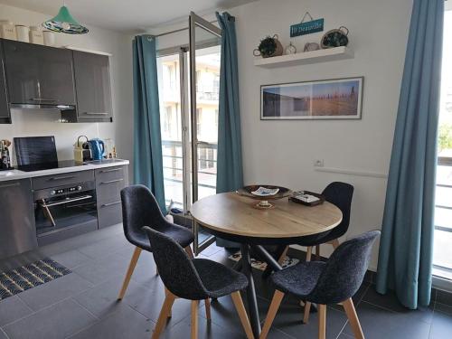 une cuisine et une salle à manger avec une table et des chaises dans l'établissement Blue Bay, à Deauville