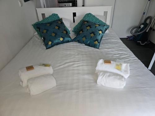 un lit blanc avec des serviettes et des oreillers dessus dans l'établissement Blue Bay, à Deauville