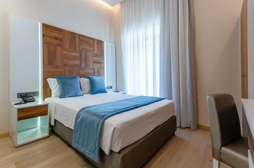 a bedroom with a bed with blue pillows and a window at Hotel Avenida Park in Lisbon