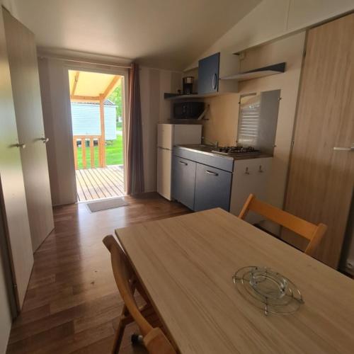 une cuisine avec une table en bois et une salle à manger dans l'établissement Chez Philippe et Sylvie - 2 bungalows pour 5 proche Europa-Park, à Boofzheim