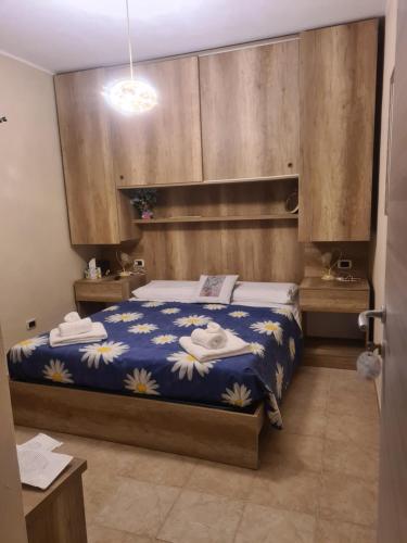 a bedroom with a bed with a blue comforter at Agriturismo Cara Terra Lucana in Chiaromonte
