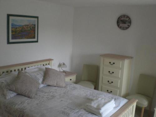 1 dormitorio con 1 cama, vestidor y reloj en Villa Azur, en Lorgues