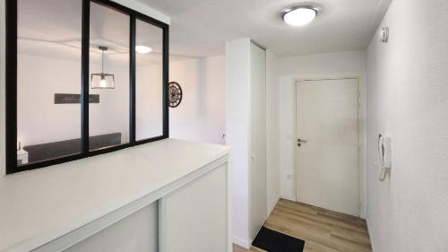 um quarto branco com uma janela e um corredor em Studio cosy élégant em Villeurbanne