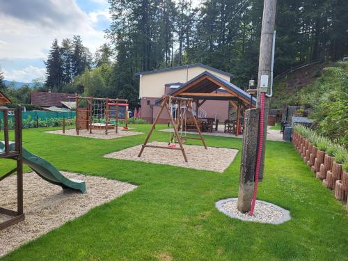 um parque com um parque infantil com um baloiço em Chata U dědka em Prostrední Becva